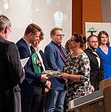 Urkunden werden an Absolventinnen und Absolventen übergeben. 